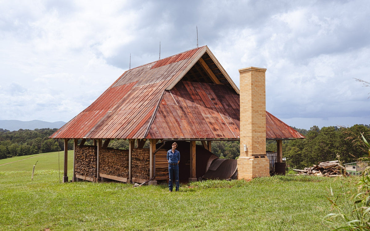 John standing in front of the woodfire kiln