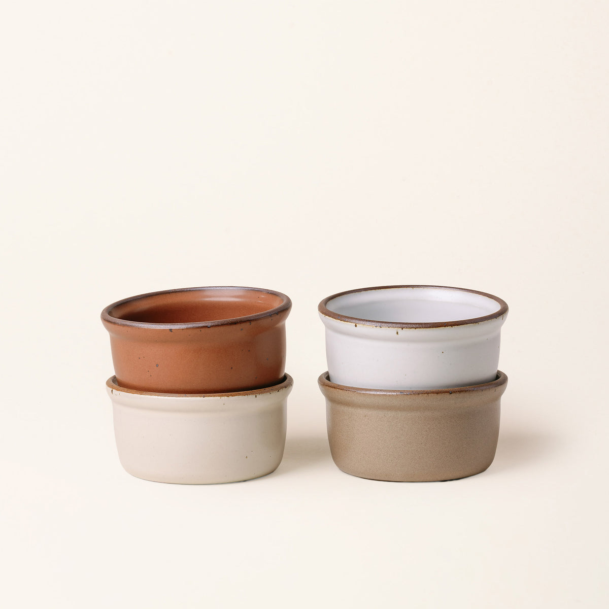 4 Medium ceramic ramekins in an off-white, cool terracotta, cool white, and warm pale brown color with an unglazed rim.