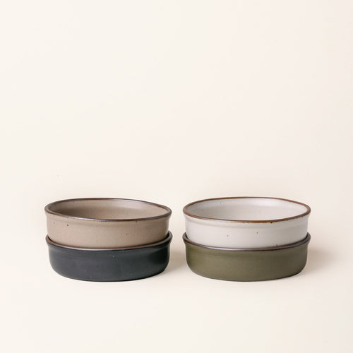 4 wide shallow ceramic ramekins in an off-white, olive green, black graphite and warm pale brown color with an unglazed rim.
