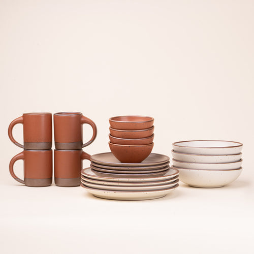 A 20-piece set of ceramic tableware, including mugs, bowls, and plates in a warm off white, cool terracotta, and pale warm brown colors.