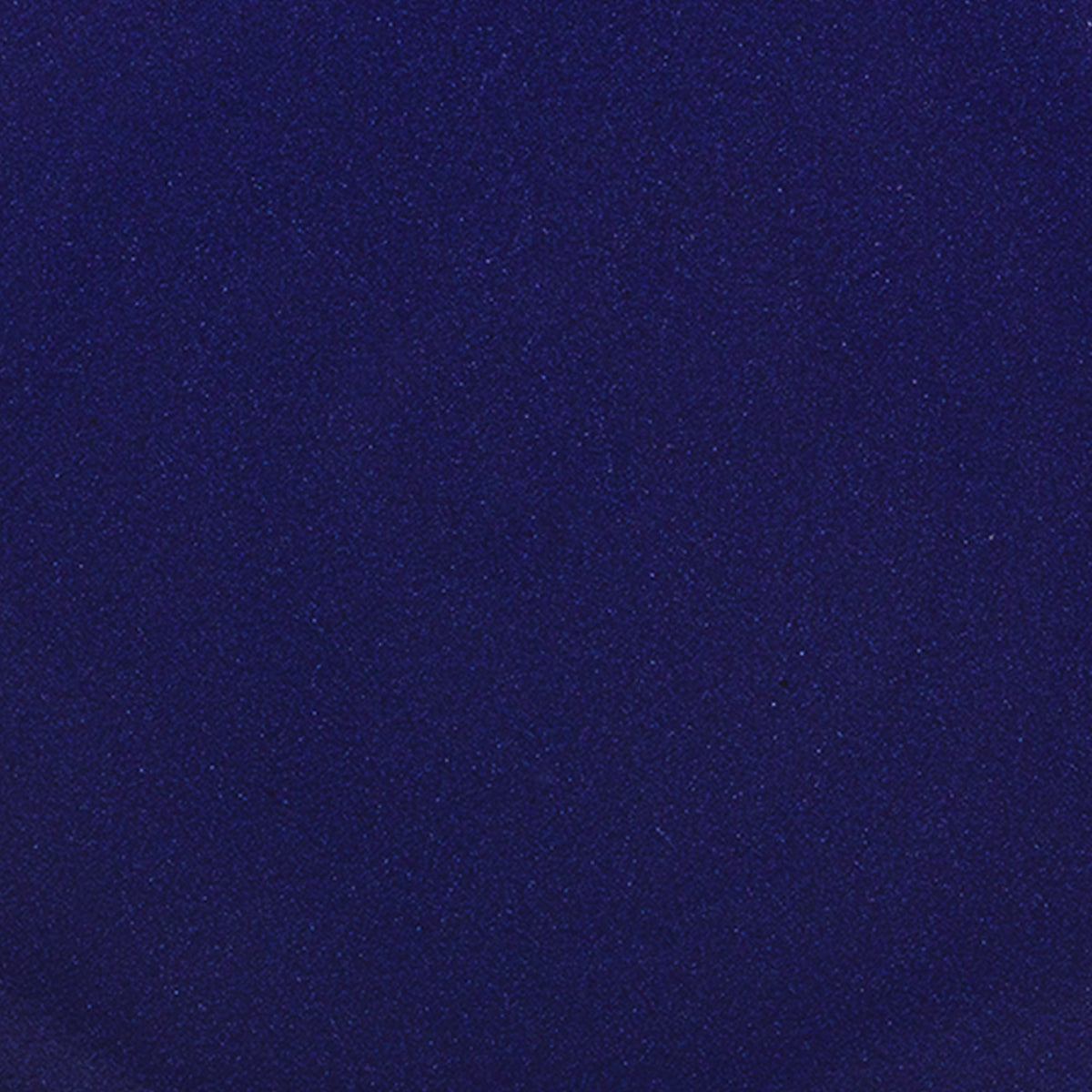 A closeup of a ceramic plate in a glossy dark blue color with iron spots