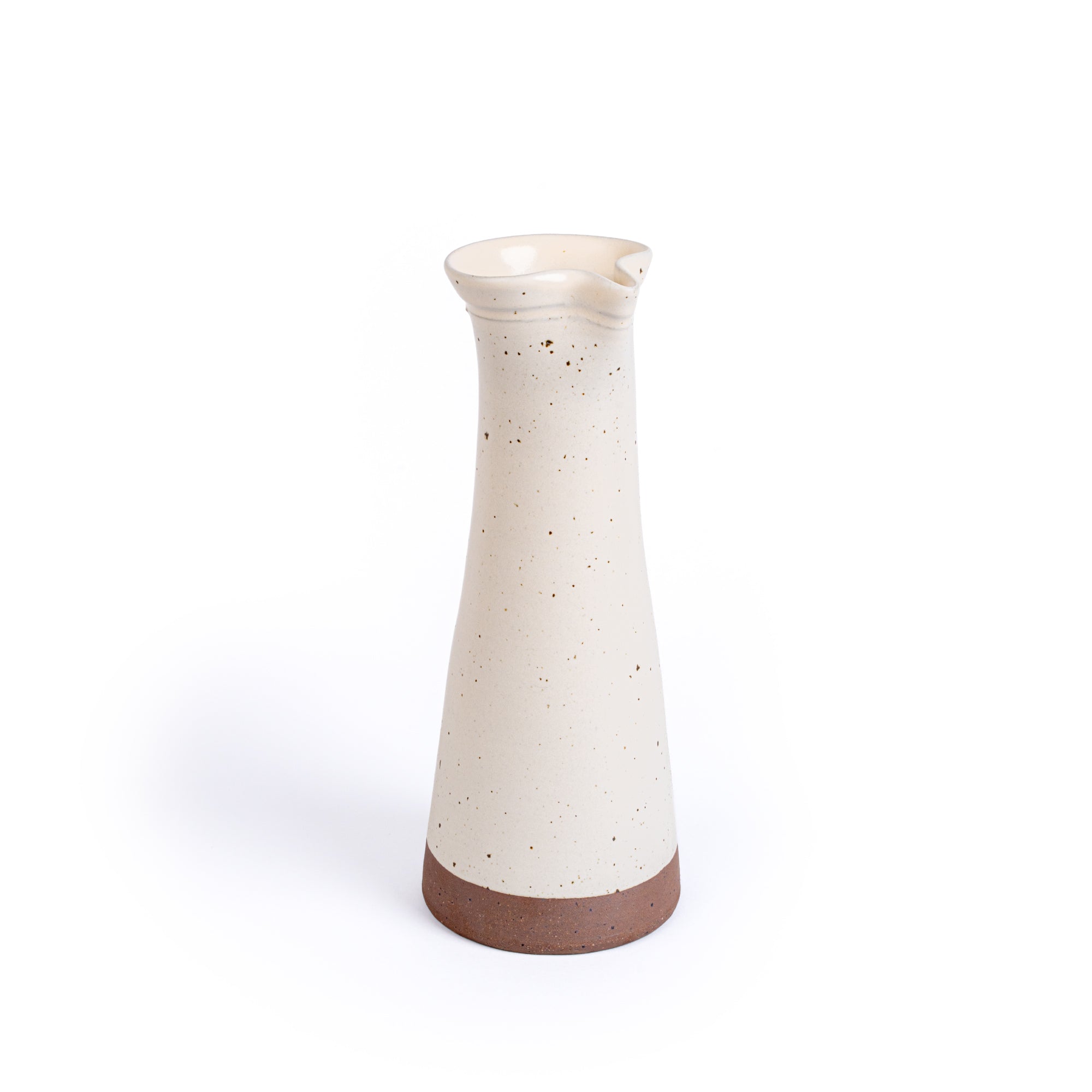Tall ceramic carafe in an off-white color with iron speckles and an unglazed base.