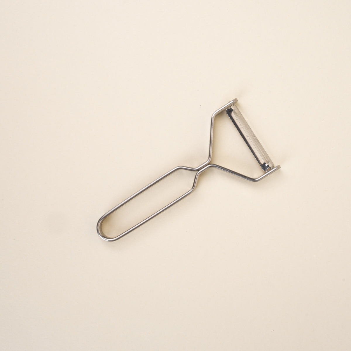 A steel peeler made of metal that has a tapered neck