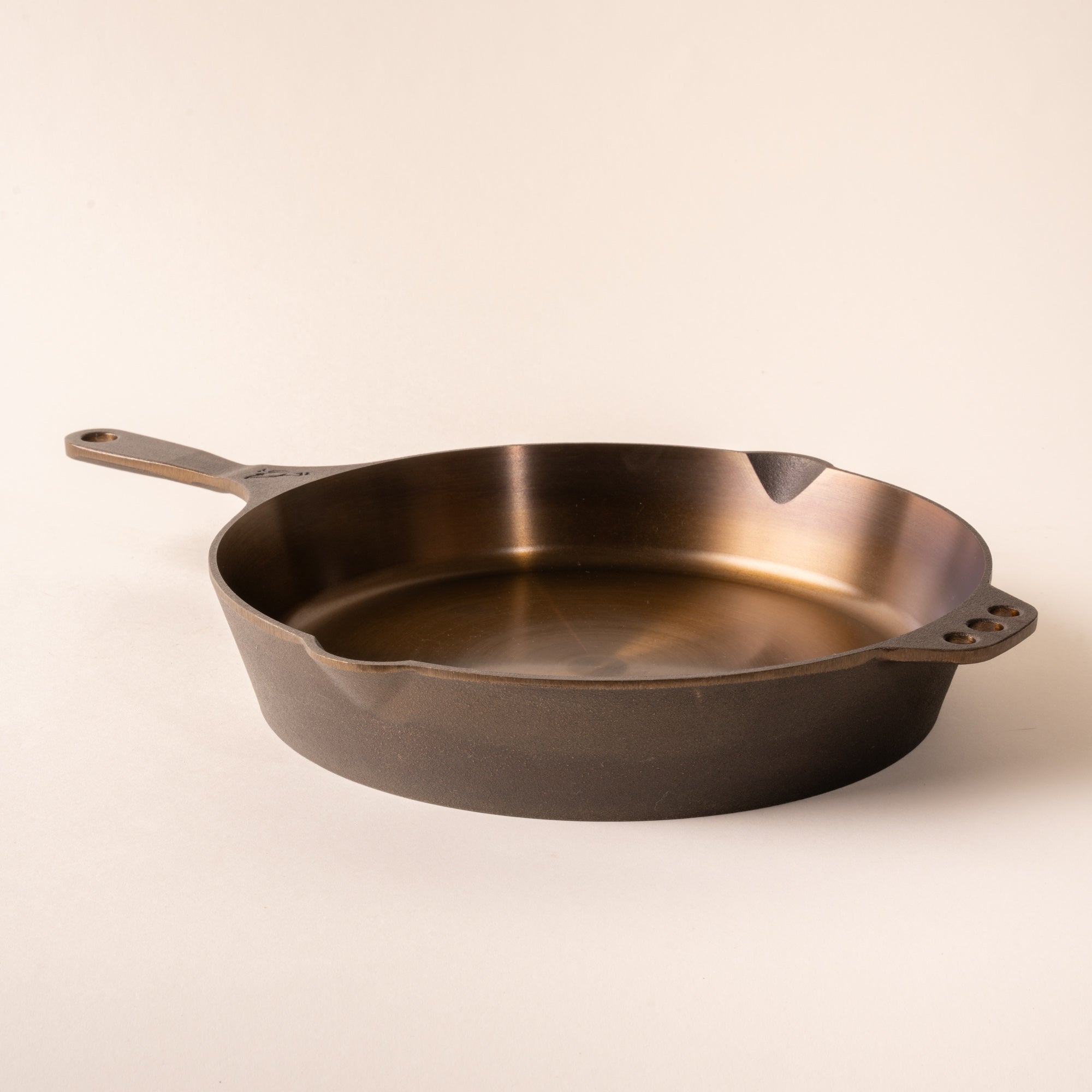 Cast iron skillet pan on a beige background