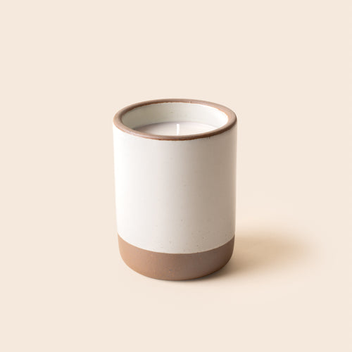 Large ceramic vessel in a cool white color with candle inside.