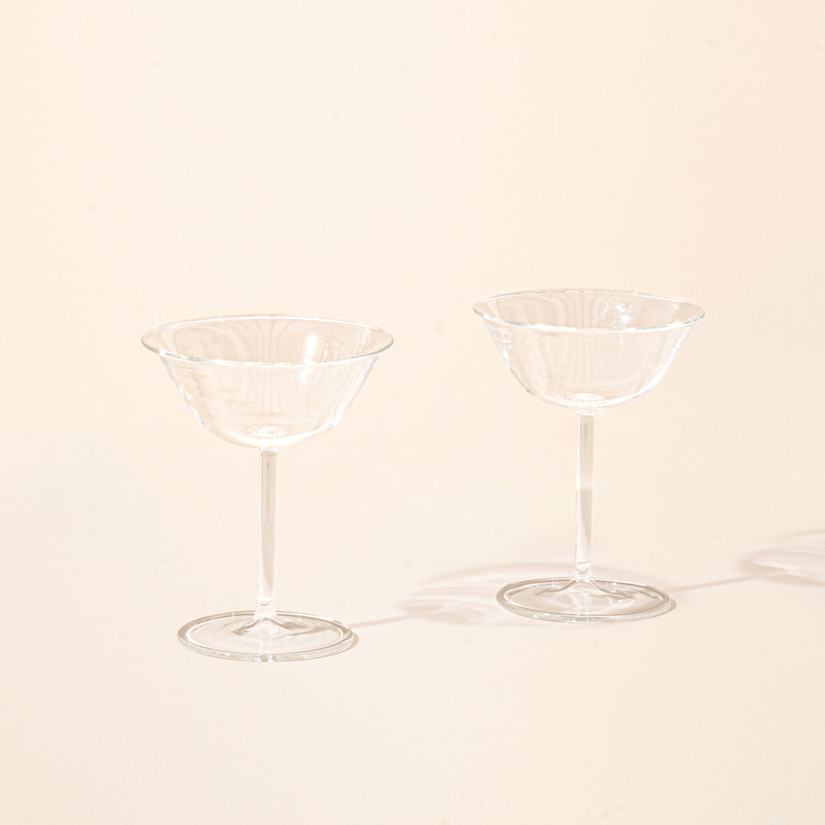 Two empty clear martini coupe glasses.