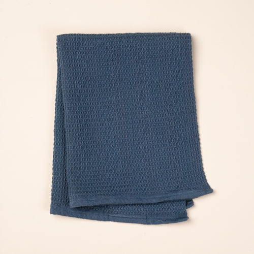 A folded blue waffle weave kitchen towel