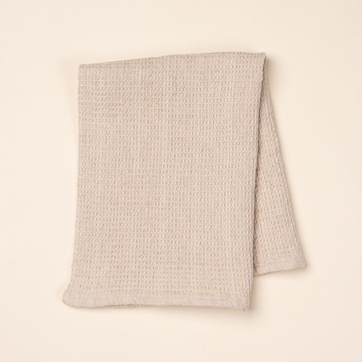 A folded natural waffle weave kitchen towel
