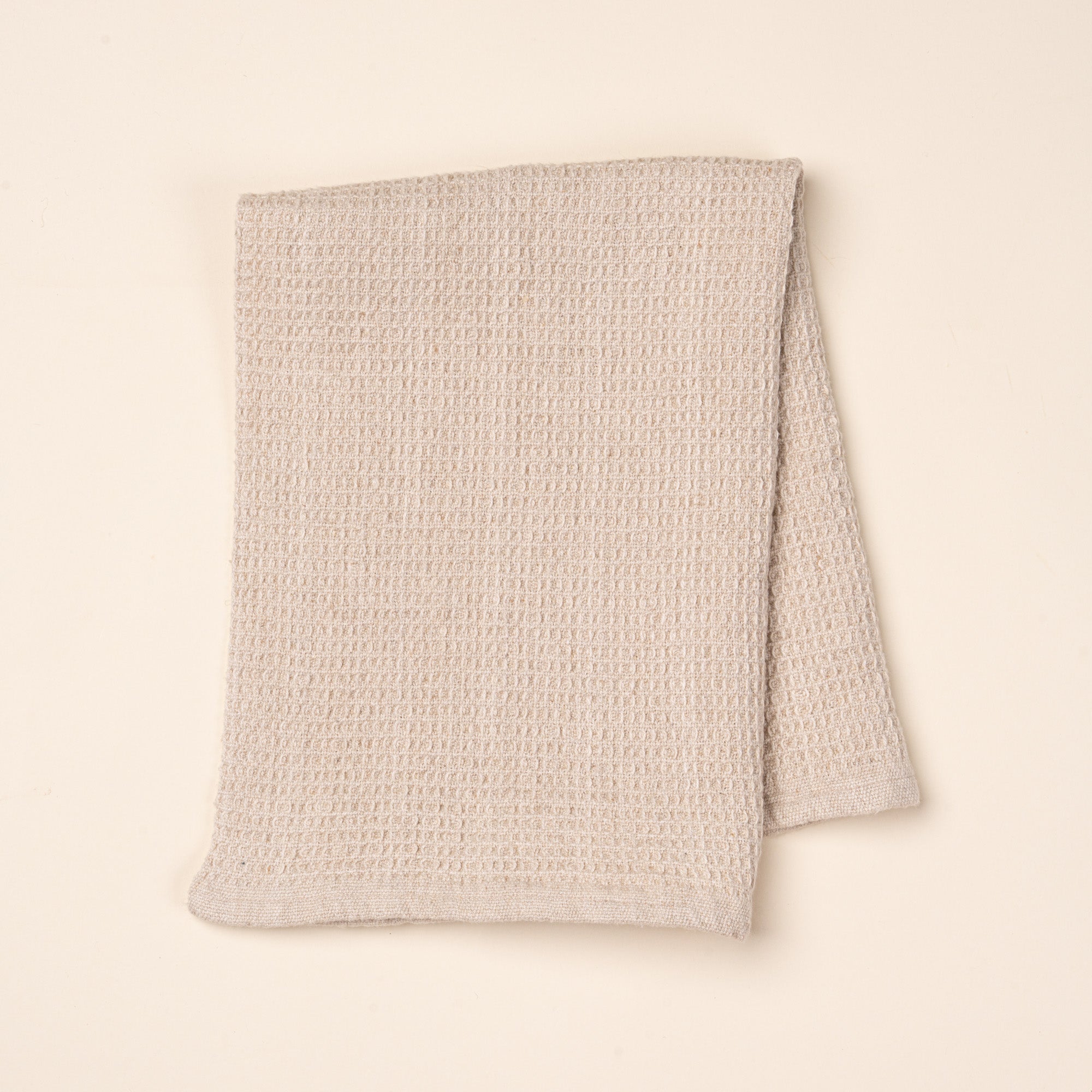 A folded natural waffle weave kitchen towel