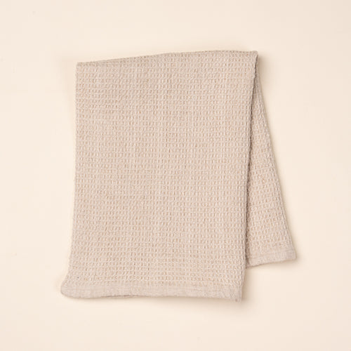 A folded natural waffle weave kitchen towel