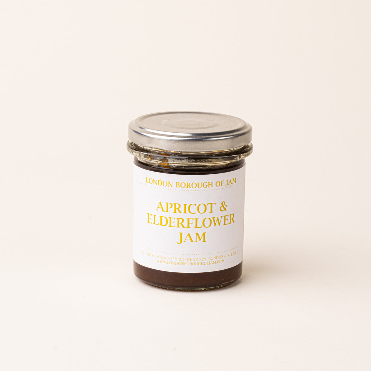 A glass jar with a white label of 'Apricot & Elderflower Jam'