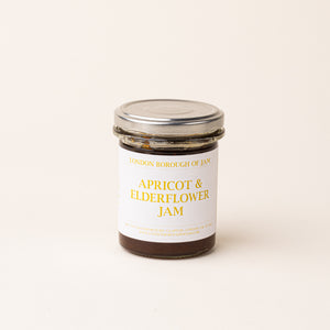 A glass jar with a white label of 'Apricot & Elderflower Jam'