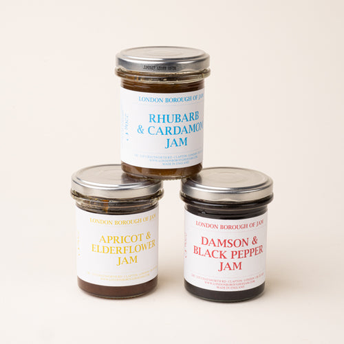 Three glass jars with a white label of Damson & Black Pepper, Apricot & Elderflower, and Rhubarb & Cardamom Jams
