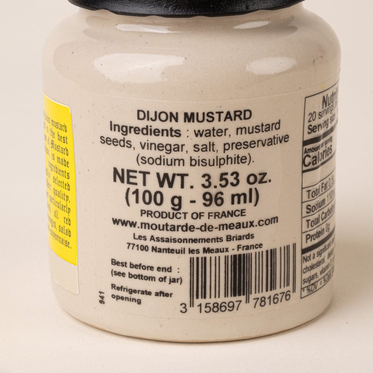 Close-up of the back of a Pommery Dijon mustard jar showing the ingredients, product information, and barcode.