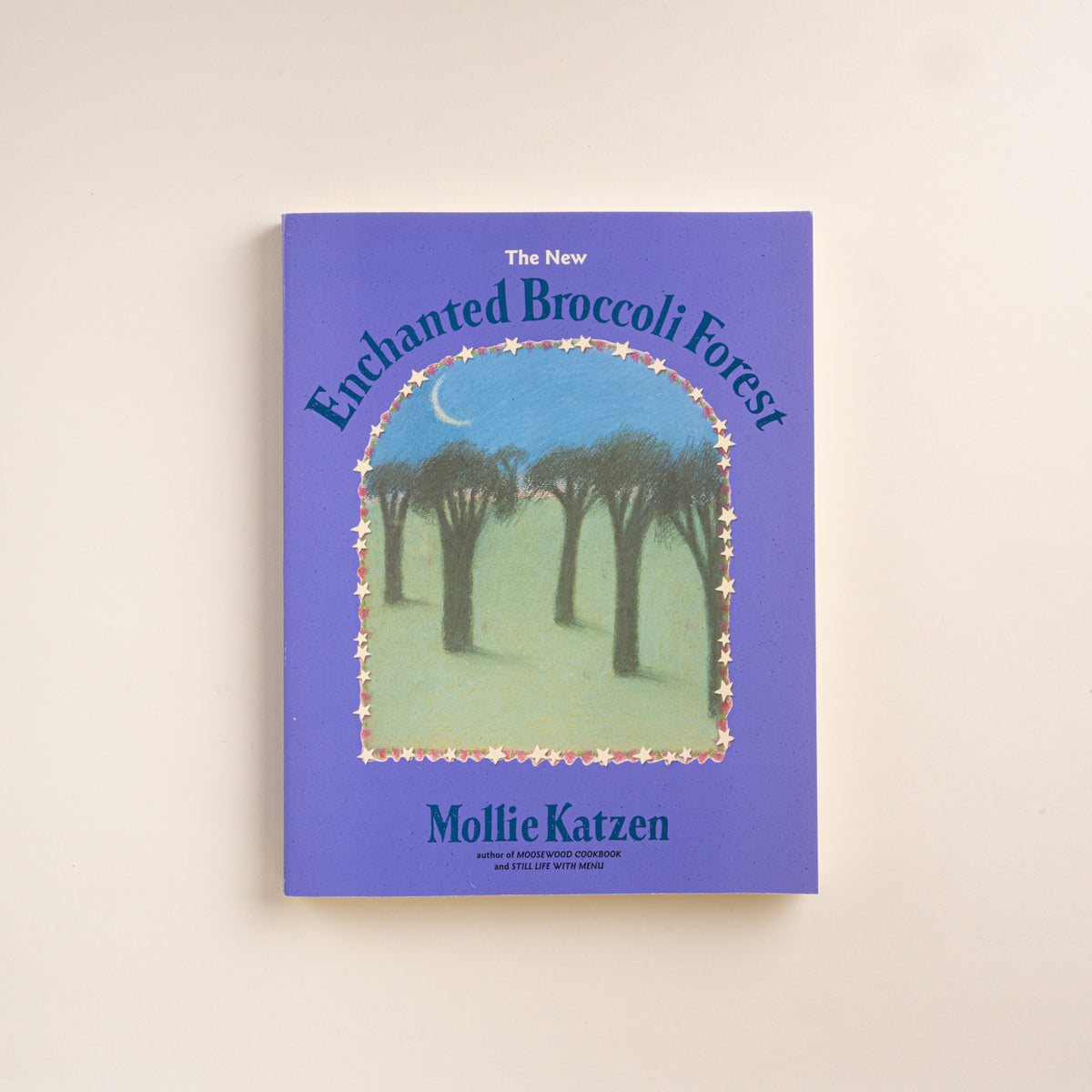 Purple cover of The New Enchanted Broccoli Forest cookbook by Mollie Katzen, featuring an illustrated forest scene.