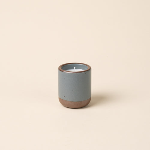Small ceramic vessel in a blue-grey color with candle inside.