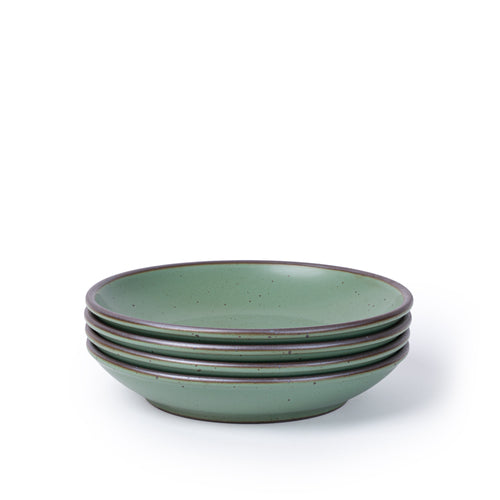 A stack of 4 medium ceramic plates with a curved bowl edge in a cool green color featuring iron speckles and an unglazed rim.