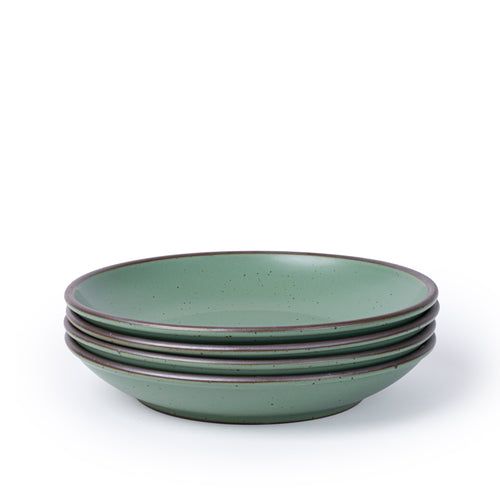 A stack of 4 large ceramic plates with a curved bowl edge in a cool green color featuring iron speckles and an unglazed rim.