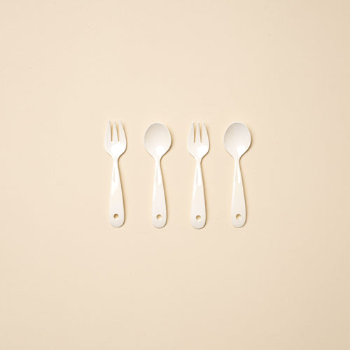 4 white enamel mini forks and spoons in a row.