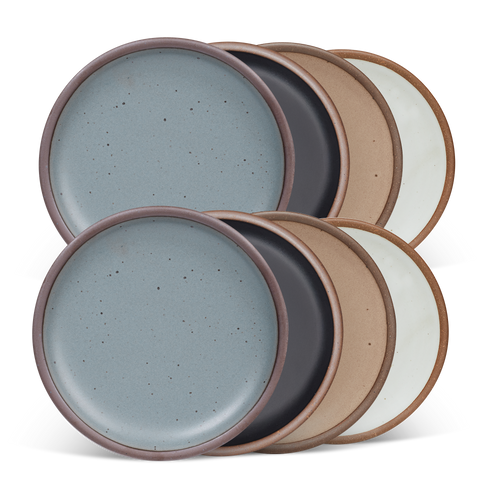 8 medium sized ceramic plates in a blue-grey, graphite black, warm pale brown, and cool white colors featuring iron speckles and an unglazed rim.