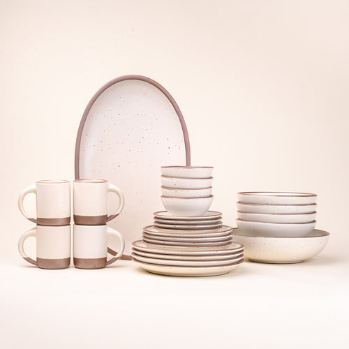 A 26-piece tablesetting with four mugs, four cake plates, four side plates, four dinner plates, 4 shallow bowls, 4 ice cream bowls, a large shallow bowl and an oval platter in a warm off-white color
