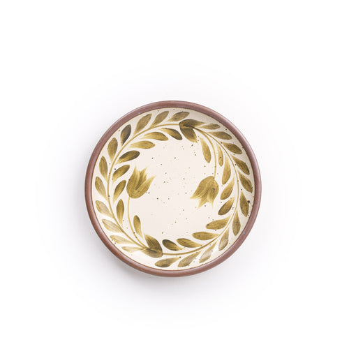Side round ceramic plate with a hand-painted olive green leaf wreath and floral design on a cream background with an exposed clay rim.