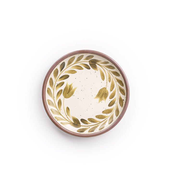 Side round ceramic plate with a hand-painted olive green leaf wreath and floral design on a cream background with an exposed clay rim.