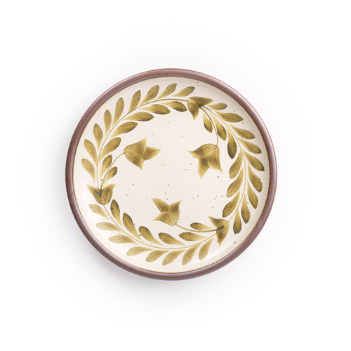 Dinner round ceramic plate with a hand-painted olive green leaf wreath and floral design on a cream background with an exposed clay rim.