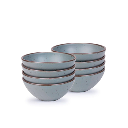 A stack of 8 medium rounded ceramic bowls in a blue-grey color featuring iron speckles and an unglazed rim