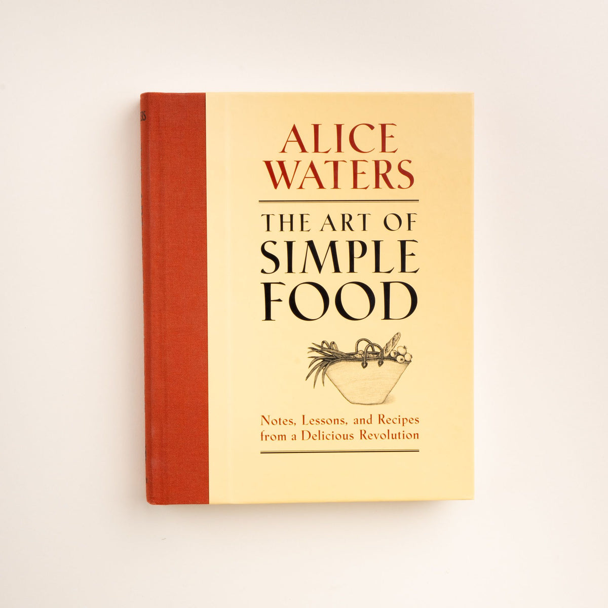 Cover of the book The Art of Simple Food by Alice Waters, featuring a yellow background, red spine, and a black line drawing of a bowl of vegetables.