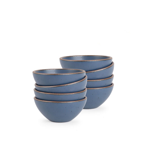 A stack of 8 small dessert sized rounded ceramic bowls in a cool, medium blue color featuring iron speckles and an unglazed rim