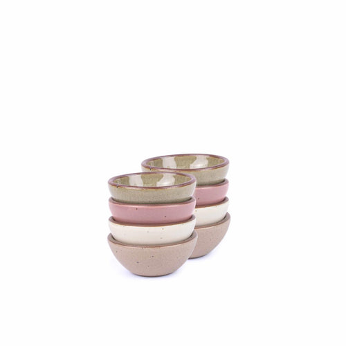 A stack of 8 tiny rounded ceramic bowls in a reflective dappled grey-green, warm off-white, warm pale brown and dusty mauve pink colors featuring iron speckles and an unglazed rim