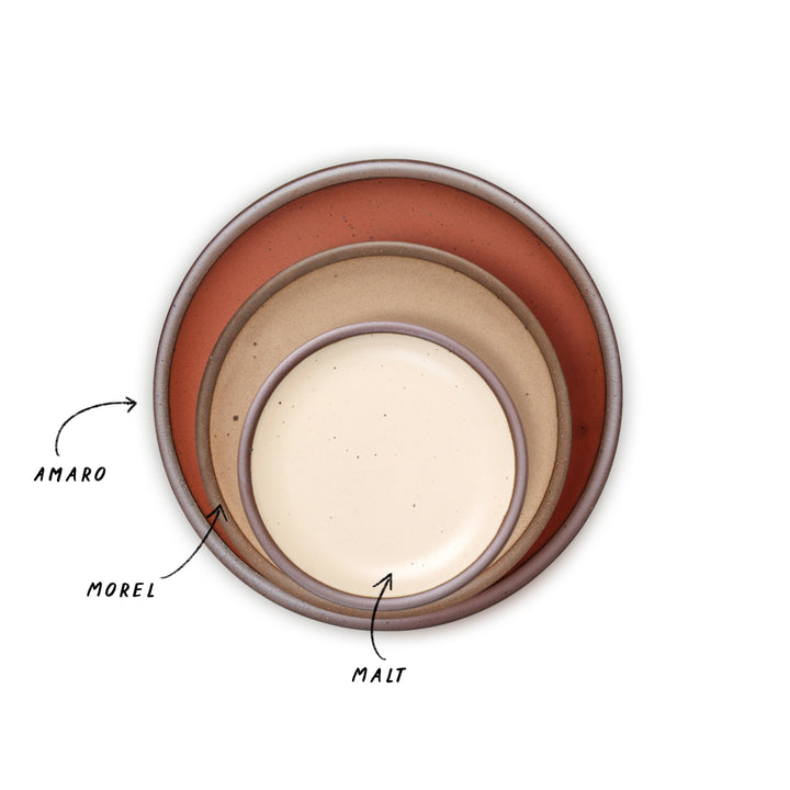 A trio of nesting plates in cream, warm pale brown, and cool terracotta colors.