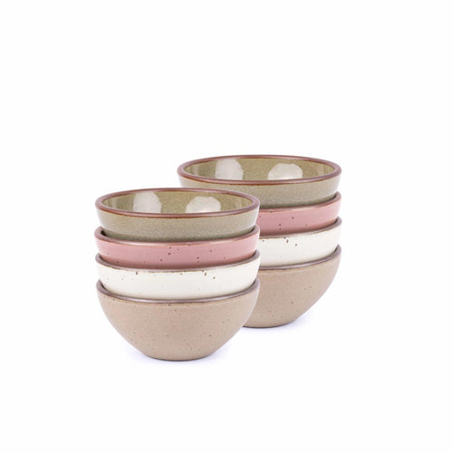 A stack of 8 small dessert sized rounded ceramic bowls in a reflective dappled grey-green, warm off-white, warm pale brown and dusty mauve pink colors featuring iron speckles and an unglazed rim