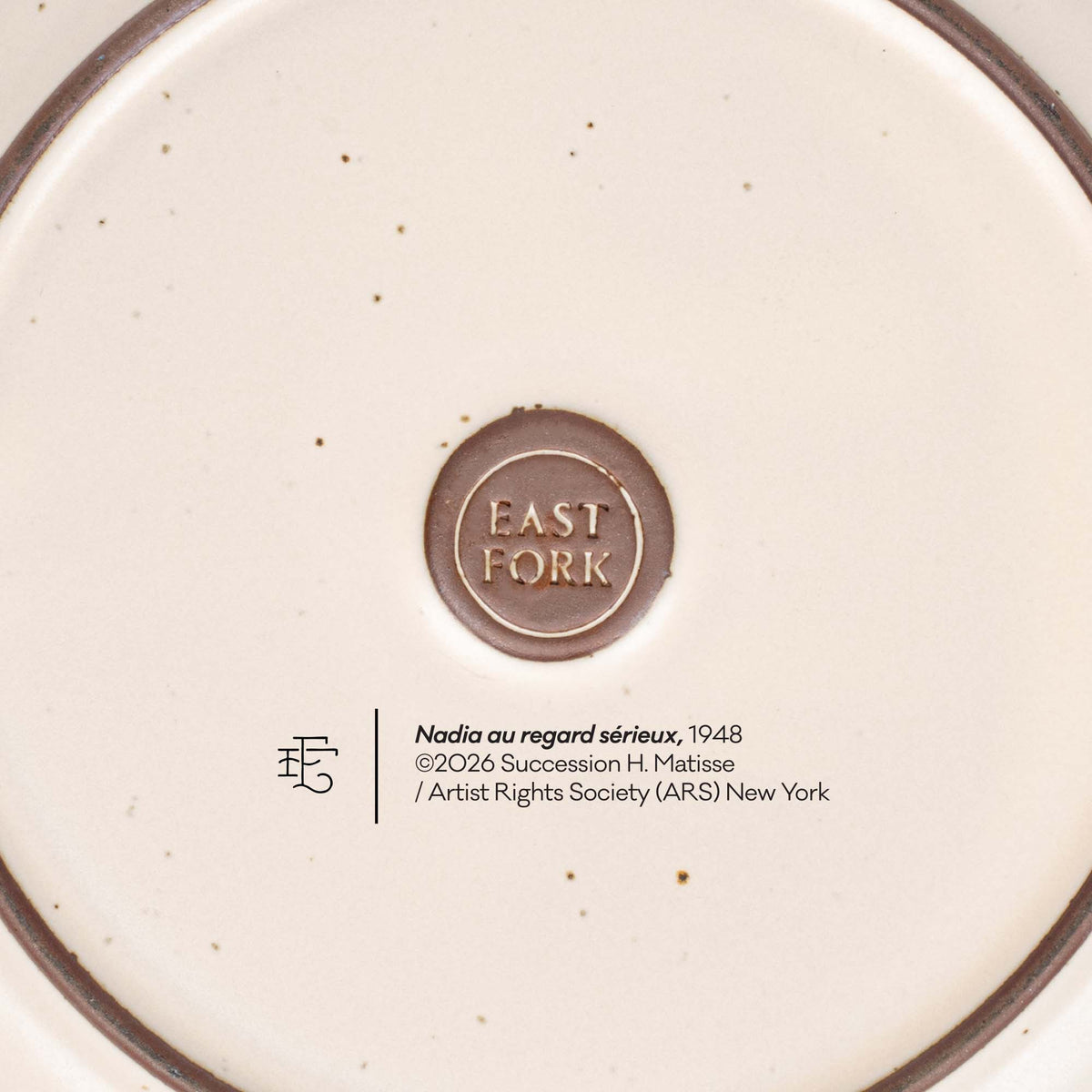 The back of a side plate with an East Fork stamp with a small decal of information about the artwork, Nadia au regard sérieux, by Henri Matisse.