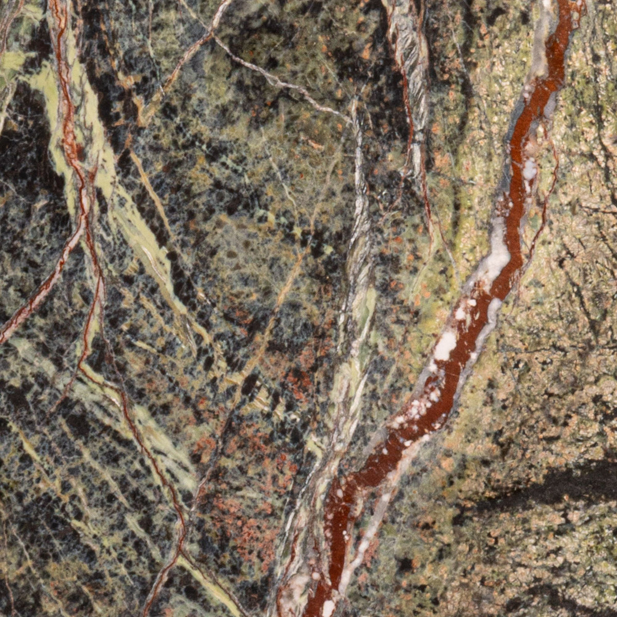 Close-up of green and beige marble surface with fine veins and speckled textures.