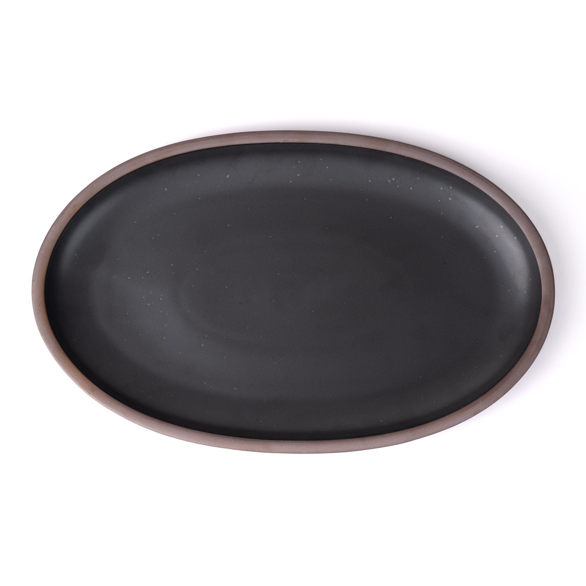 A large oval ceramic platter in a graphite black featuring iron speckles and an unglazed rim