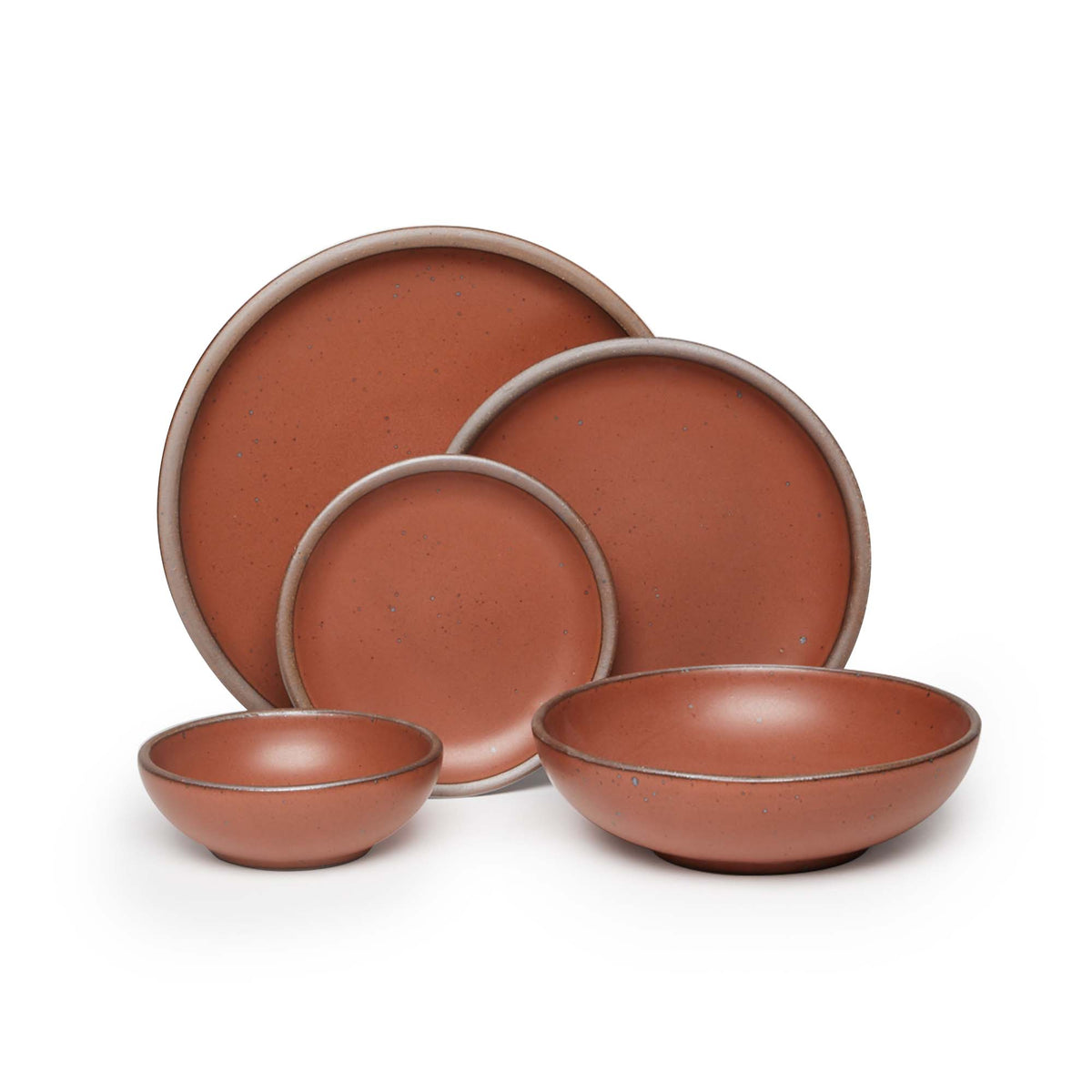 A breakfast bowl, everyday bowl, cake plate, side plate and dinner plate paired together in a cool burnt terracotta featuring iron speckles
